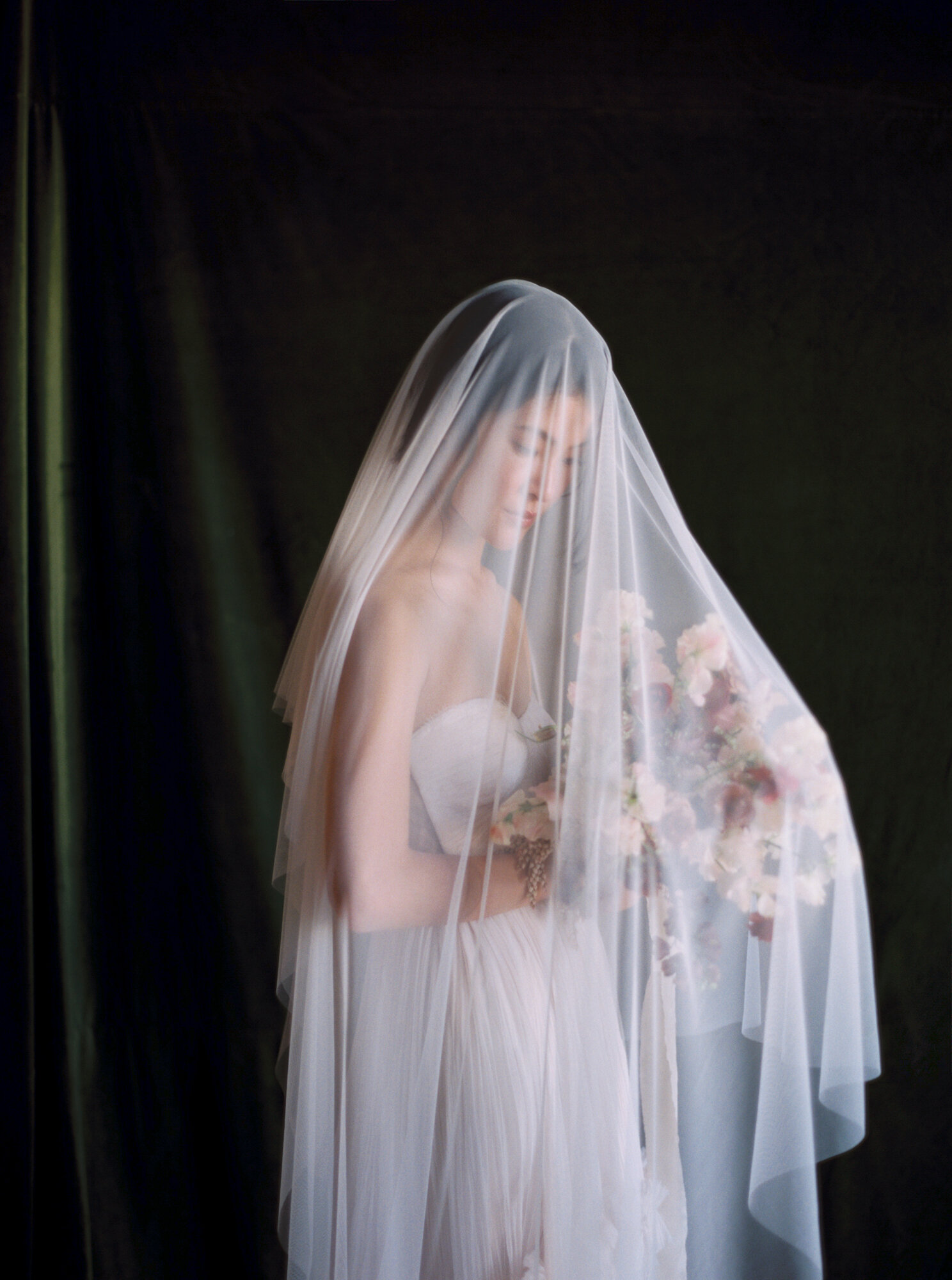 Bride covered in veil against dark backdrop in Los Angeles, by JS Rhos