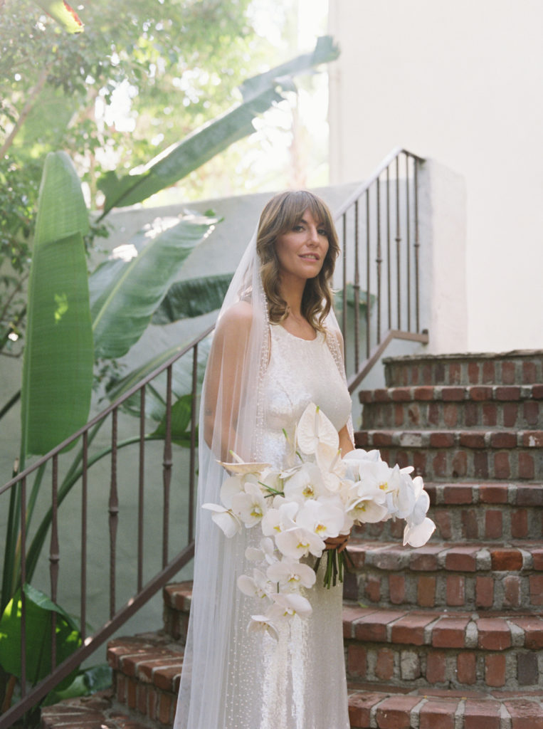 Bride on stairs in Sunset Marquis, Los Angeles by JS Rhos