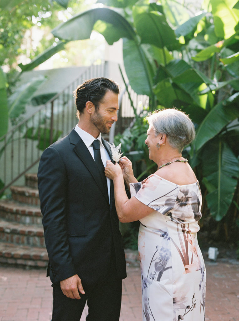 Groom and mother of groom pining boutonniere on at Sunset Marquis