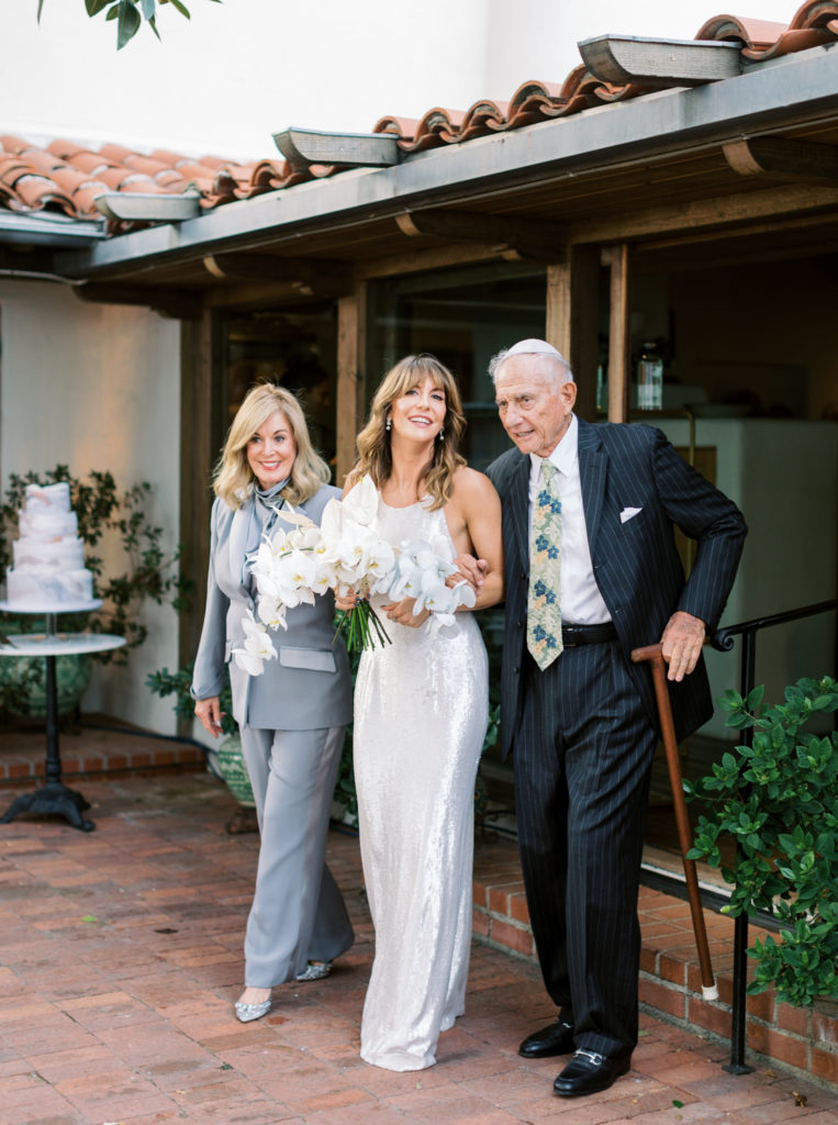 Bride walking down aisle with parents in Los Angles