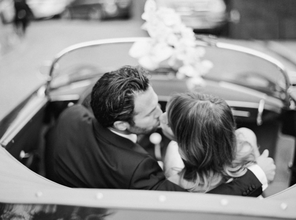 Bride and groom kissing in car in Los Angeles